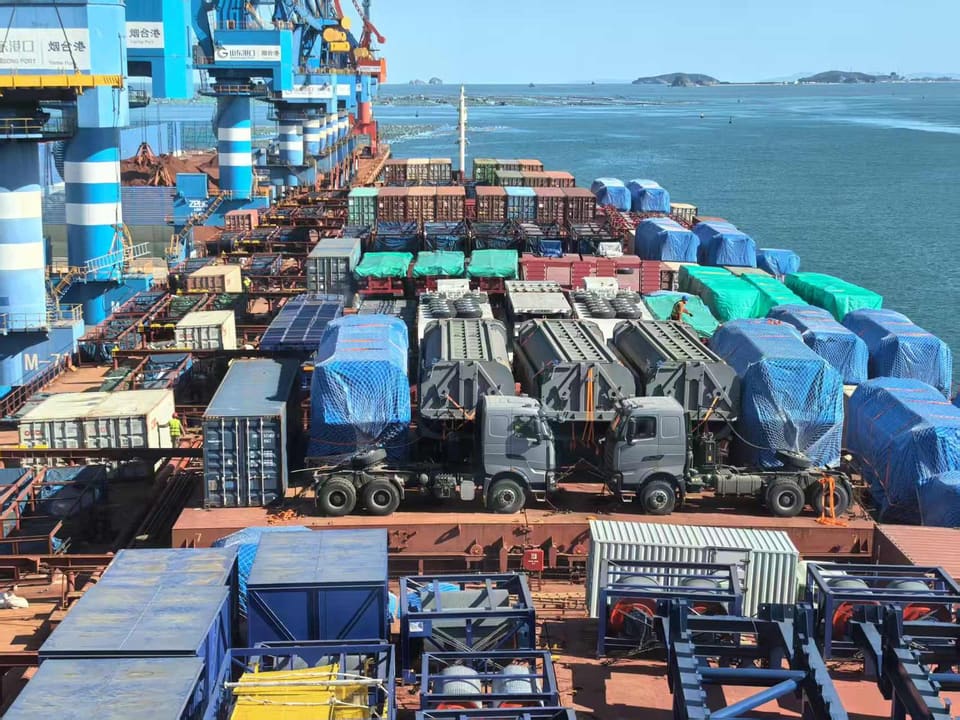 Construction machinery lashed on the open deck of a cargo vessel at sea
